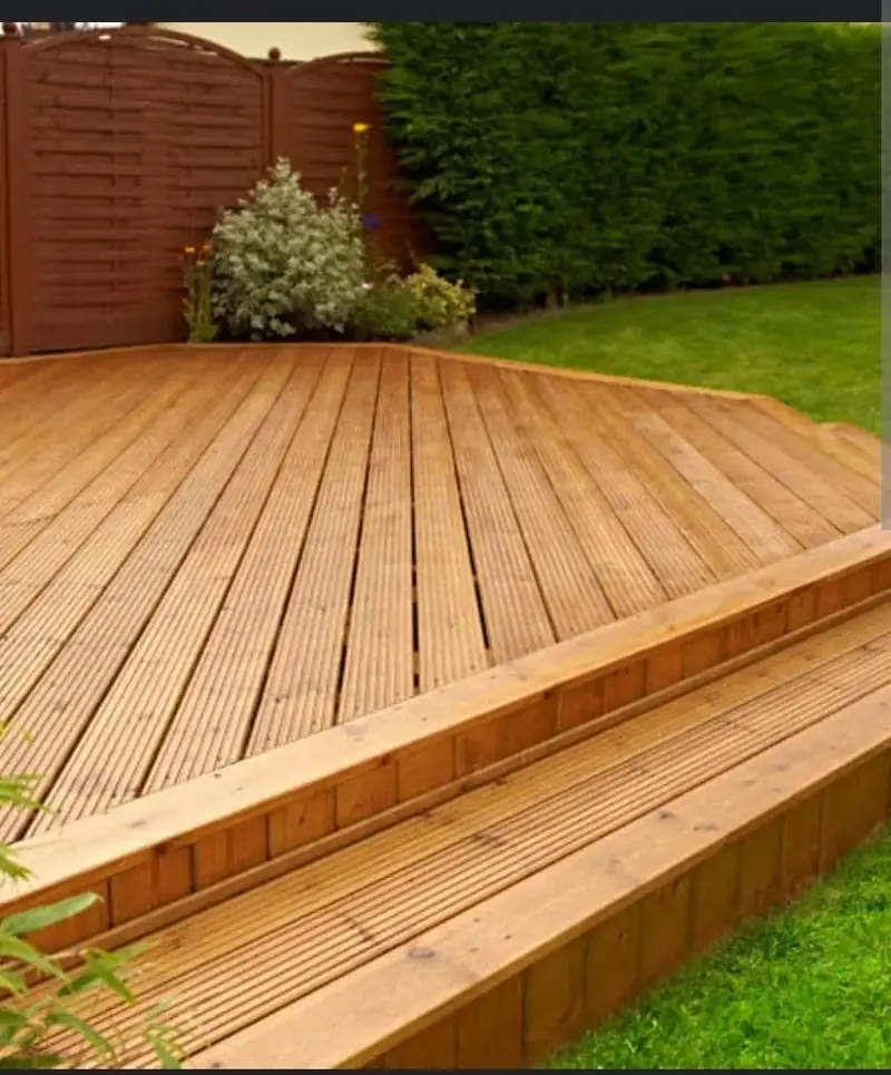 Timber deck with a step down to the lawn and a slatted fence behind
