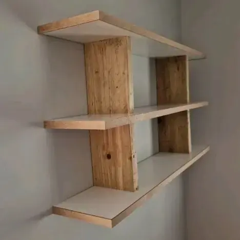 Three floating shelves with birch-ply edges held by rough-sawn vertical timbers