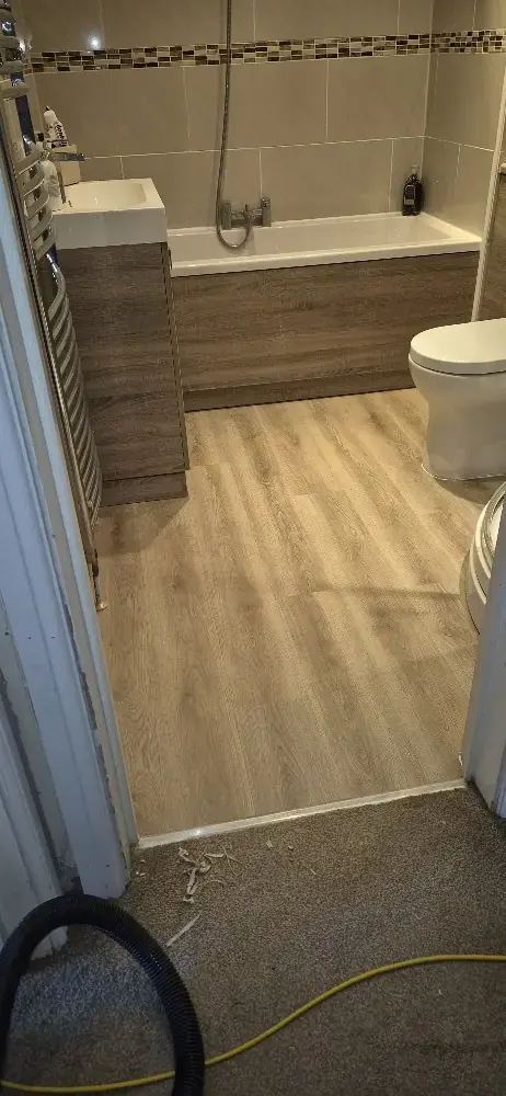 Bathroom with a new wood-effect floor and fitted bath panel