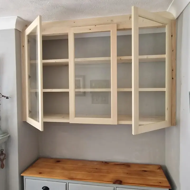 Pine glazed wall cabinet mounted over a sideboard