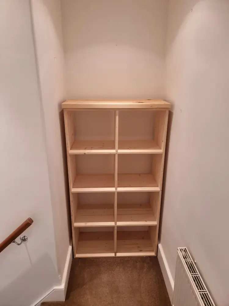 Pine shelving unit fitted into a narrow alcove on a landing