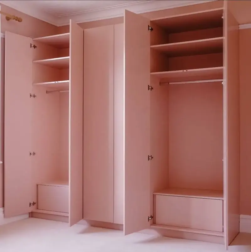 Open pink wardrobe with two hanging sections and a drawer at the base