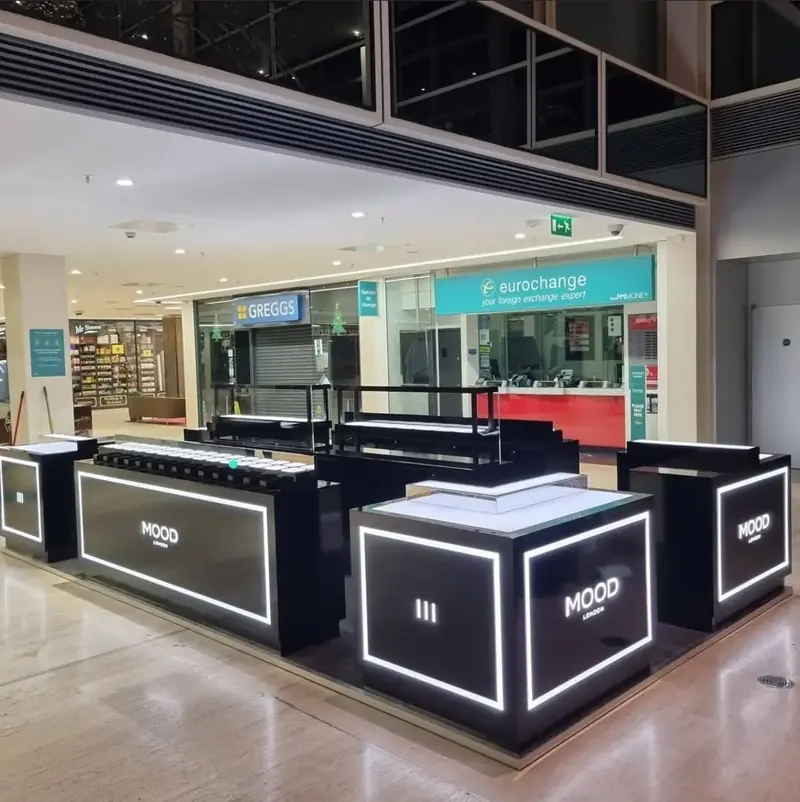 Black retail kiosk with illuminated white edges in a shopping centre