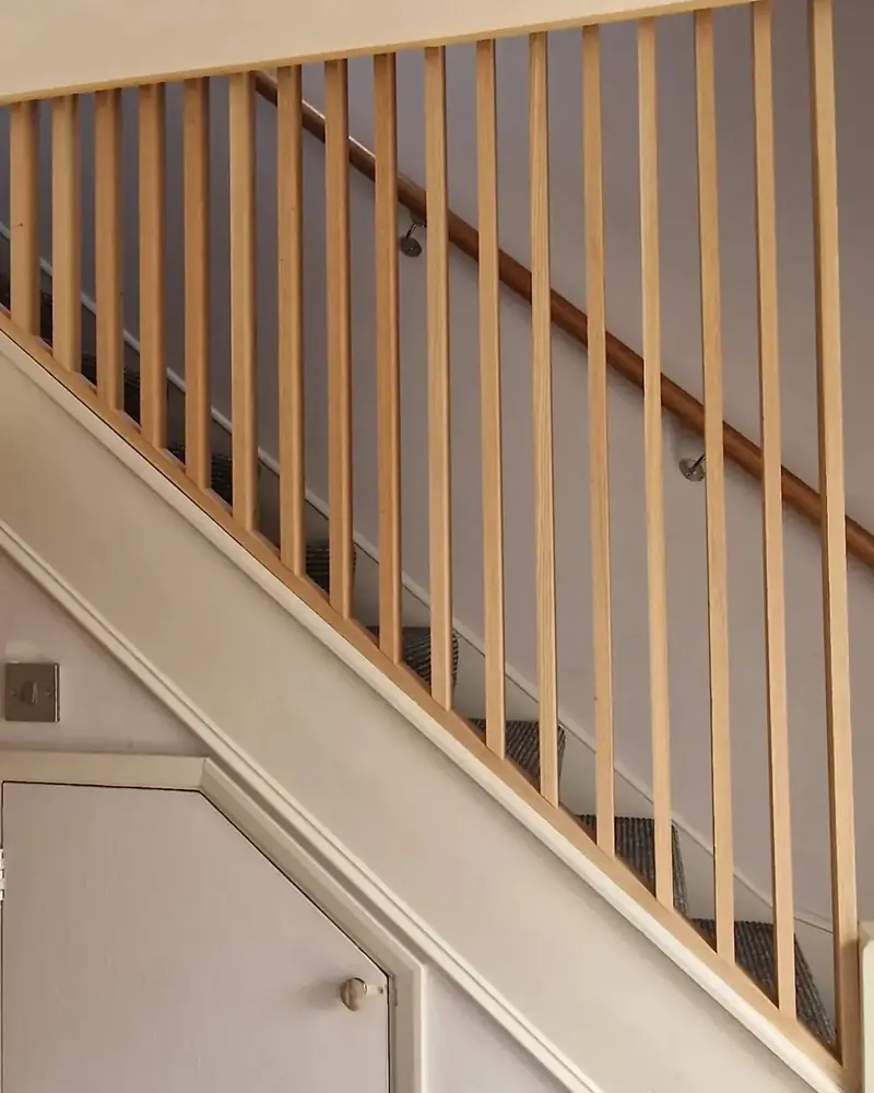 Timber staircase handrail with evenly spaced square pine spindles