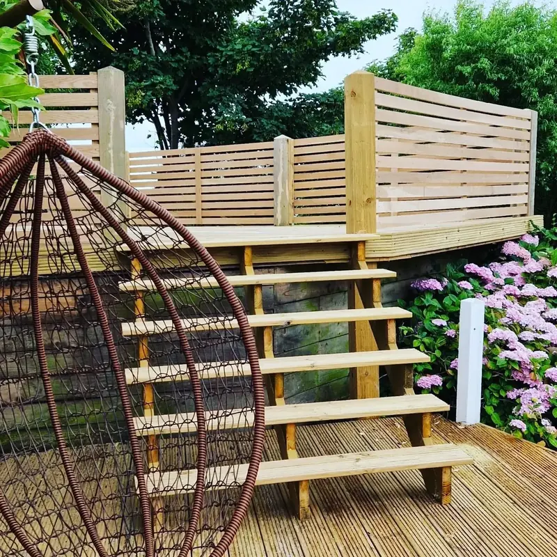 Raised garden deck with horizontal slatted screening and timber steps down