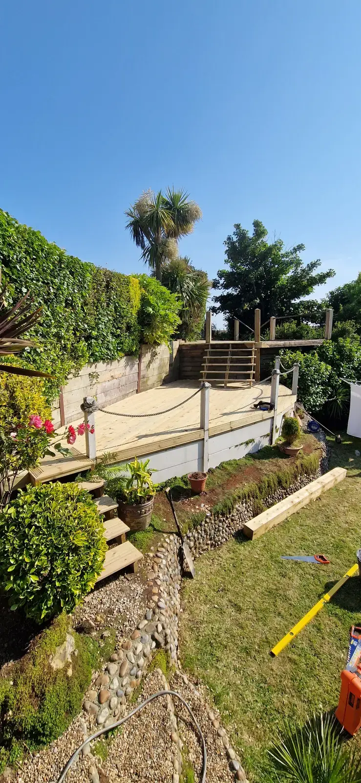 Sloping garden with timber terraces and steps