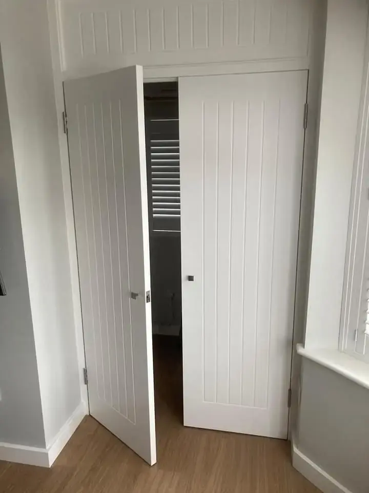 White tongue-and-groove double wardrobe doors standing open