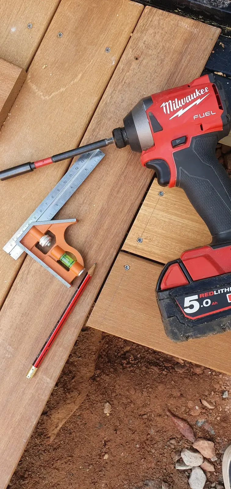 Cordless drill and square resting on timber boards